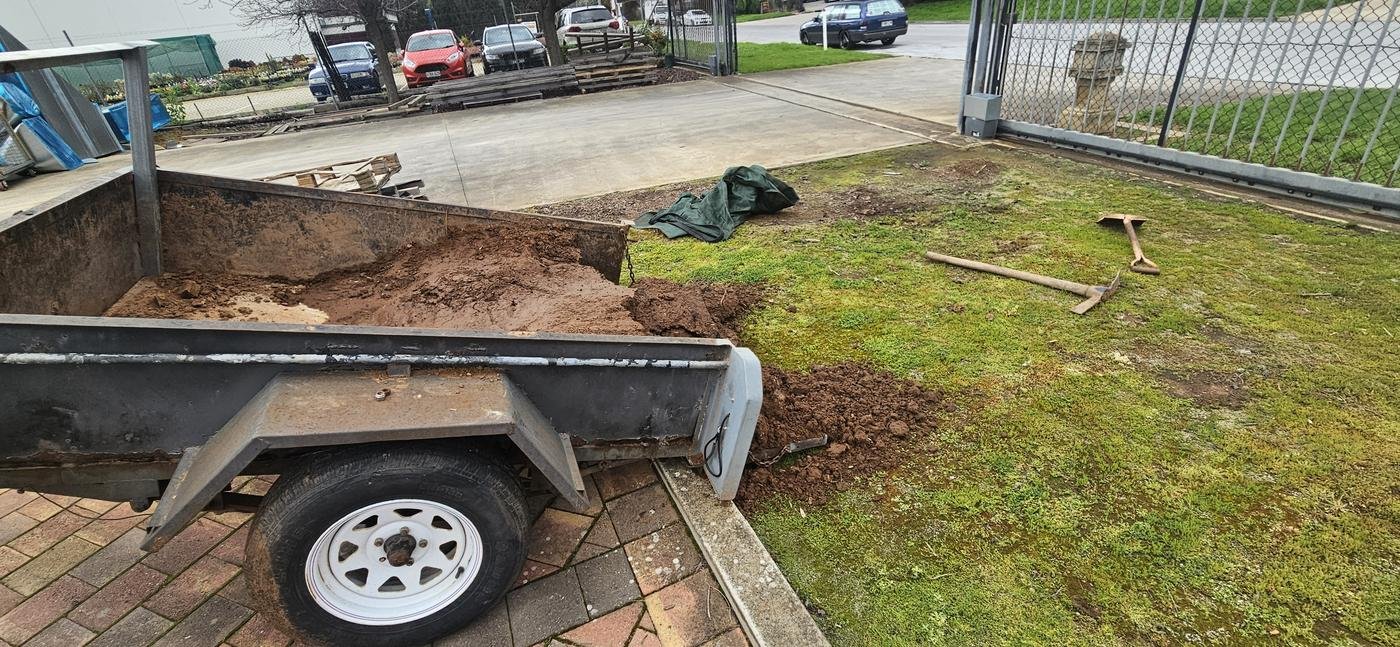 Trailer loaded with soil and garden waste for removal from a property